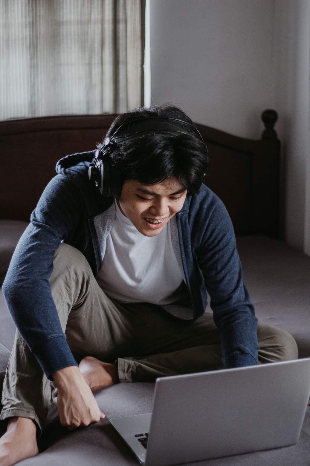 Student Using Laptop in Bed for Online Class